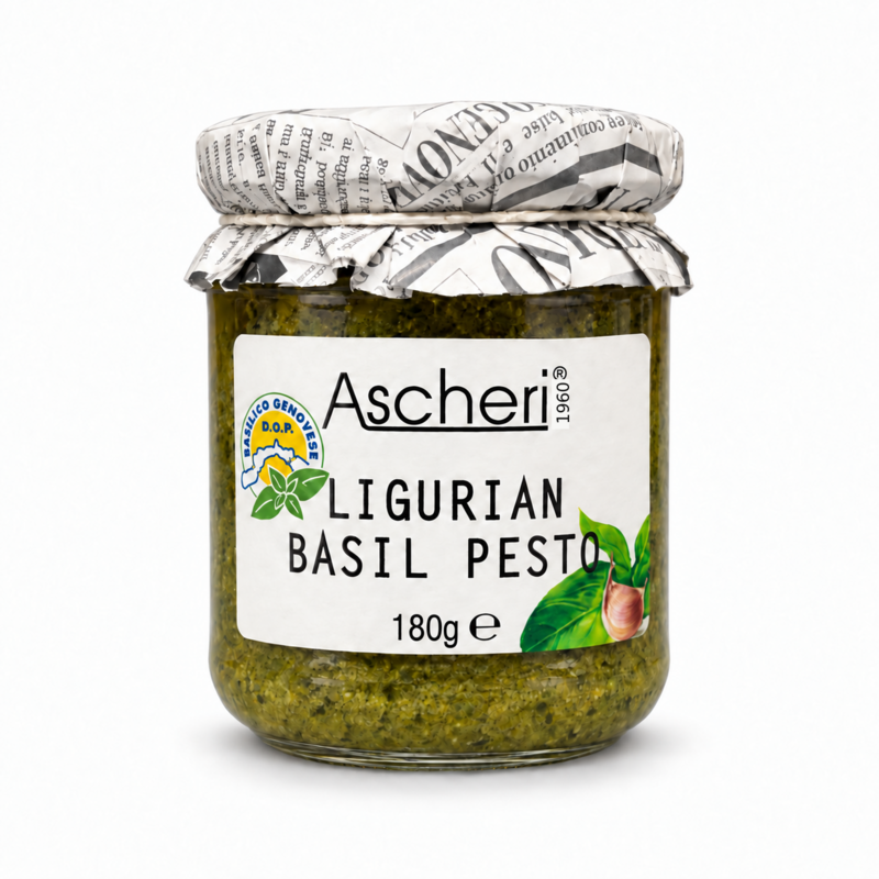 A glass jar of Ascheri Ligurian Basil Pesto, filled with green pesto and sealed with a newspaper-patterned lid, on a clean white background.