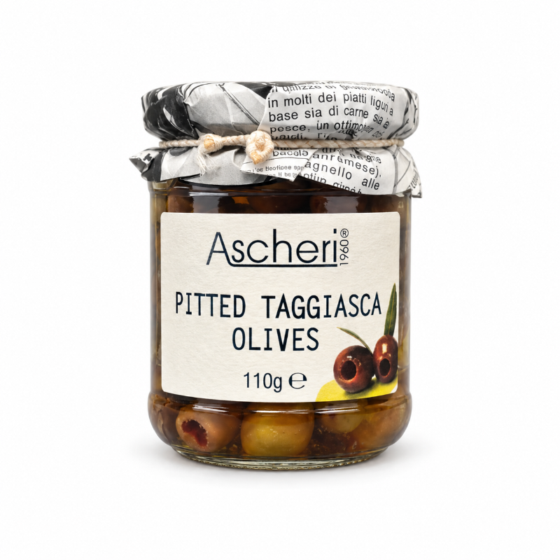 A glass jar of Ascheri Pitted Taggiasca Olives on a clean white background. The jar contains green and black olives in oil, with a white paper label and a silver foil-wrapped lid tied with a twine bow.
