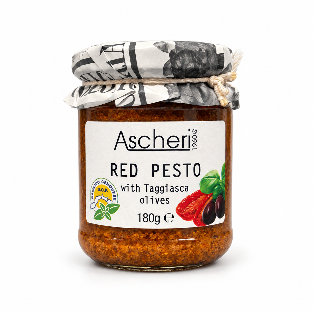 A glass jar of Ascheri Red Pesto with Taggiasca olives, featuring a white label with red and green illustrations, a newspaper-patterned lid, and a twine bow, set against a plain white background.
